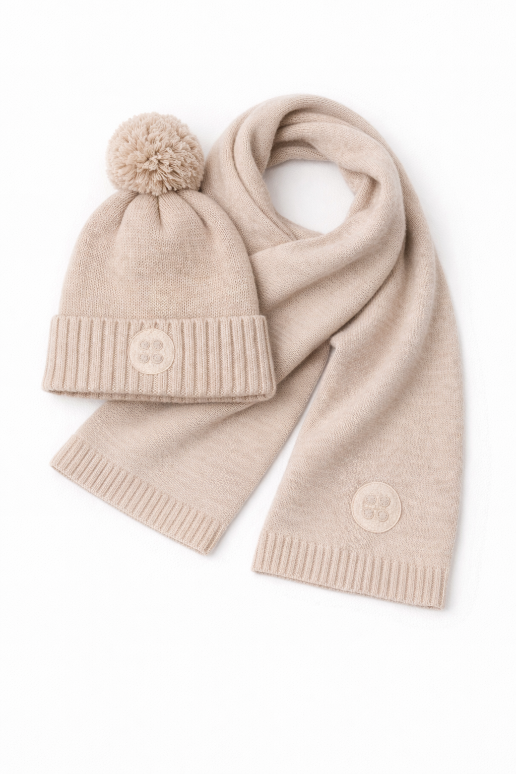 Beige knit hat with pom-pom and scarf on a white background