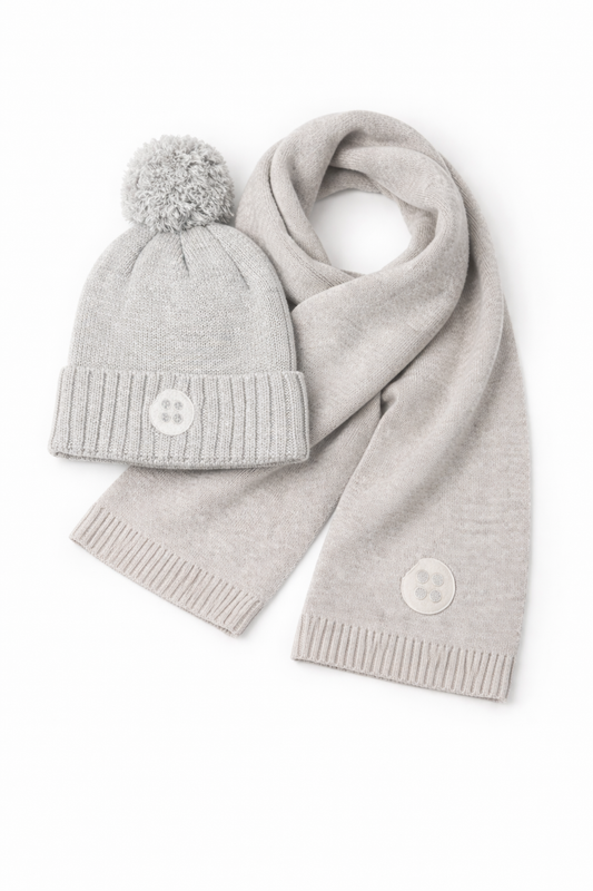 Gray knit hat with pom-pom and matching scarf on a white background